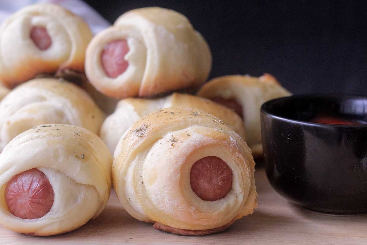 Receita de Cachorrinho Assado - faça um lanche delicioso no final de semana com massa de pão e salsicha assada.