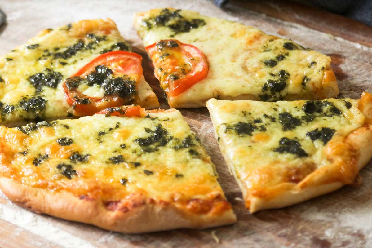 Receita de Pizza ao Pesto com Queijo e Tomate - um delicioso prato italiano para lanchar no final de semana.